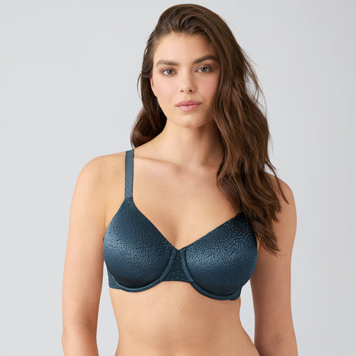 Woman wearing a green bra against a gray background