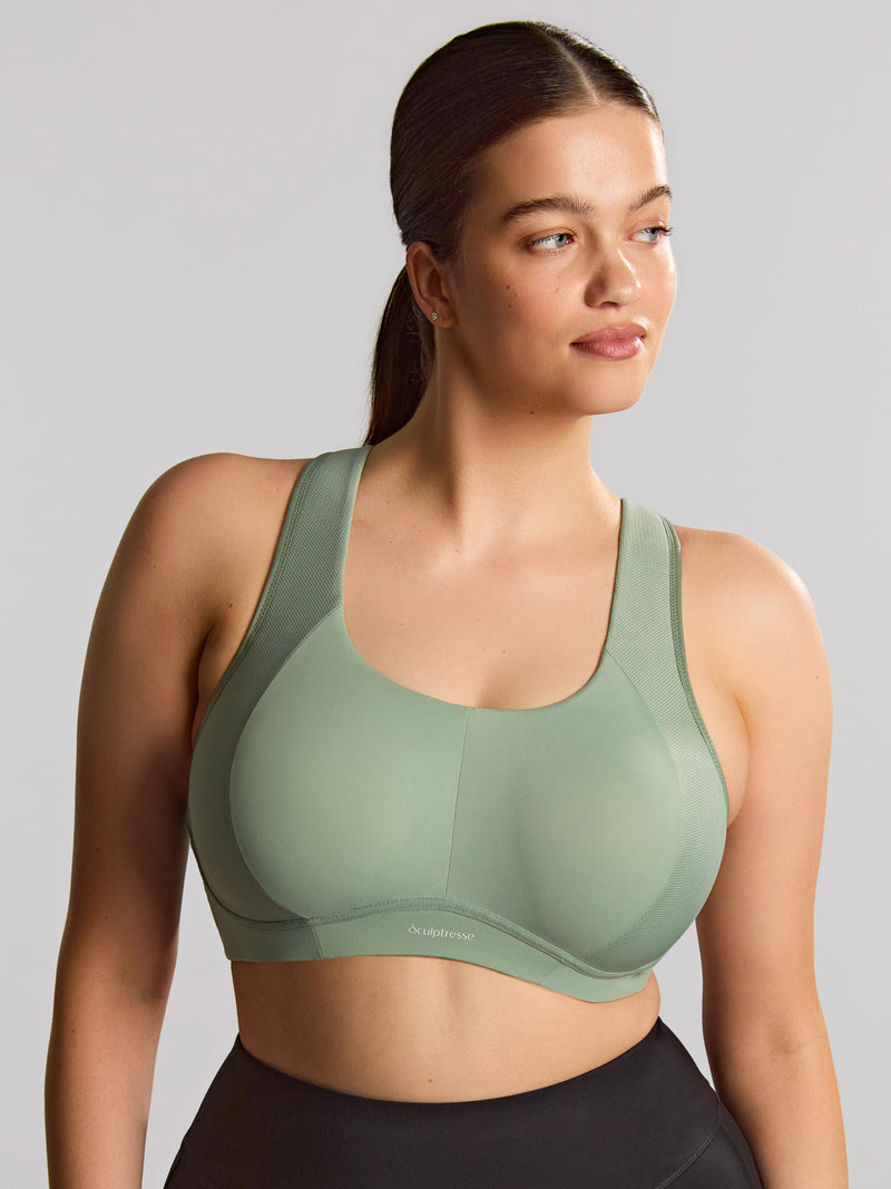 Woman wearing a green sports bra against a gray background