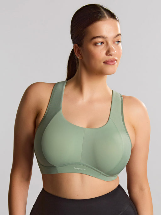 Woman wearing a green sports bra against a gray background