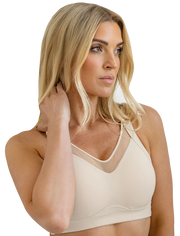 Woman wearing a beige bralette on a white background