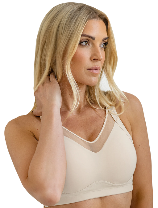 Woman wearing a beige bralette on a white background