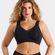 Woman wearing a black bra against a white background