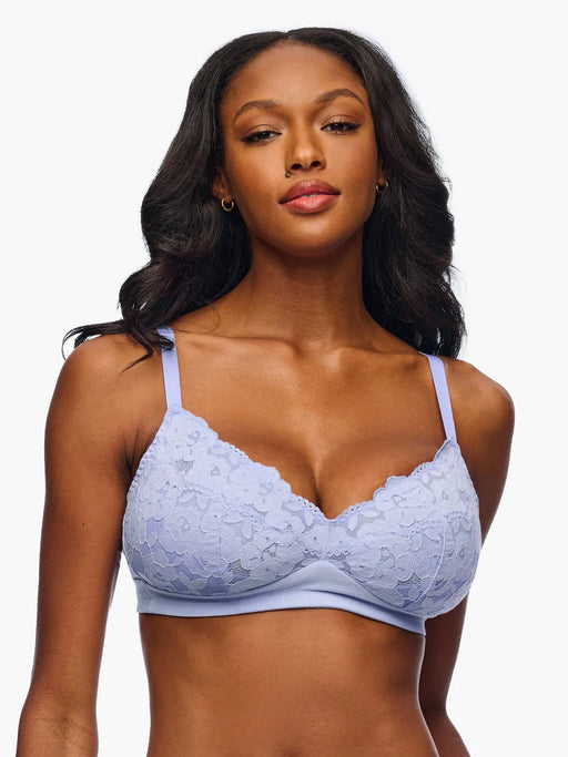 Woman wearing a light blue lace bra against a white background