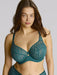 Woman wearing a teal lace bra and underwear set against a plain background